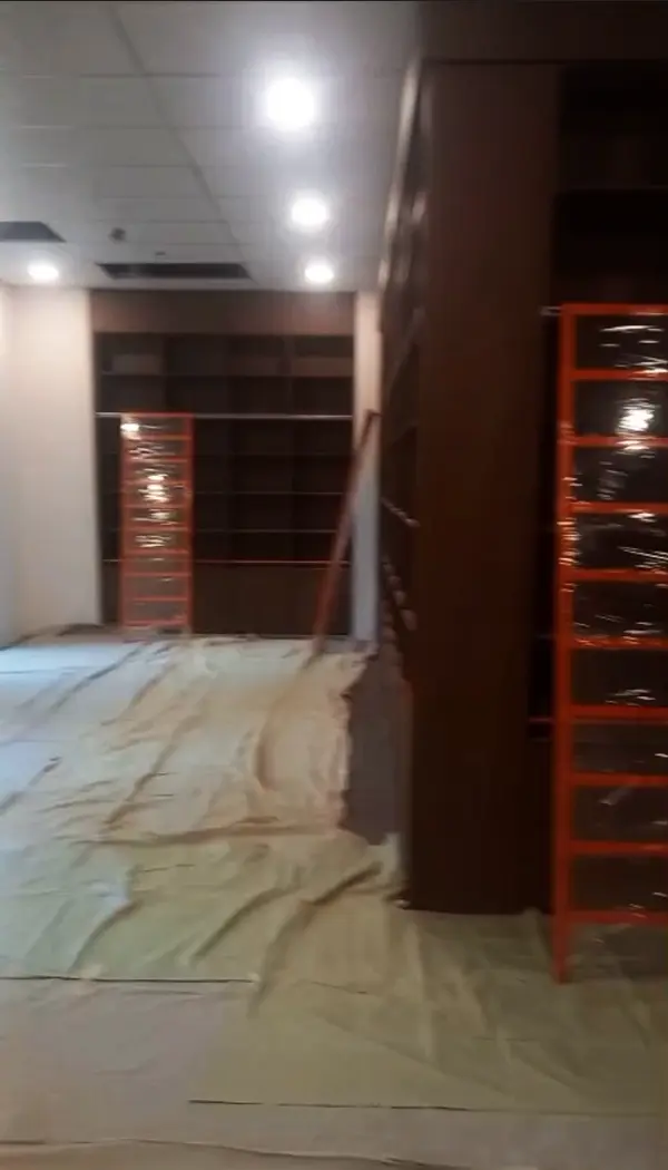 Lemari buku custom membentuk huruf L di sudut ruangan